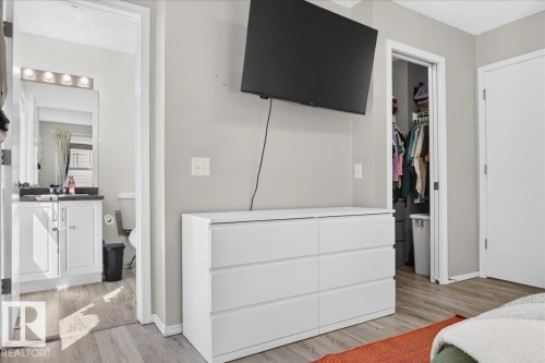 Wood-finish flooring throughout, with a built-in closet featuring shelving and hanging space - 1217 76 Street Sw, Edmonton, AB 