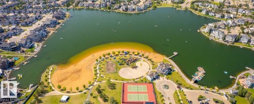 Waterfront community featuring a lake with boat docks, sandy beach area, tennis courts, and a playground - 1217 76 Street Sw, Edmonton, AB 