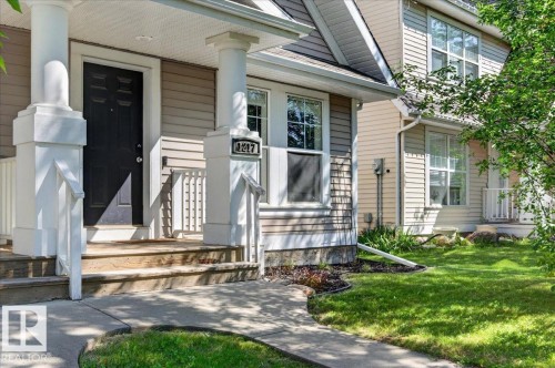 Front porch with substantial white columns and wood-finish steps - 1217 76 Street Sw, Edmonton, AB 