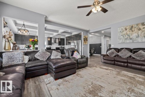 Spacious living area featuring wood-finish flooring, light gray walls, and an open layout - 5203 23A Avenue Sw, Edmonton, AB - Indoor Photo Showing Living Room