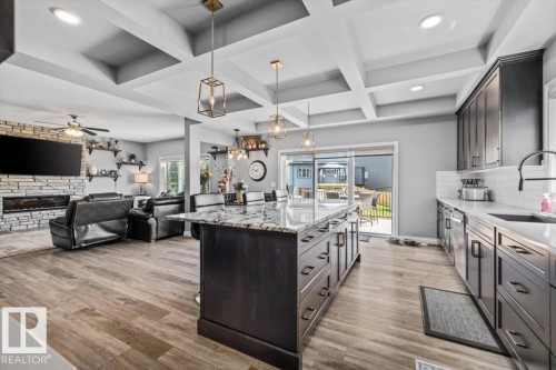 Open-concept living space featuring wood-finish flooring, a coffered ceiling, and recessed lighting - 5203 23A Avenue Sw, Edmonton, AB - Indoor Photo Showing Kitchen With Upgraded Kitchen