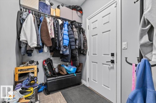 Entryway featuring a six-panel interior door with matte black hardware, tile flooring, and light gray wall paint - 5203 23A Avenue Sw, Edmonton, AB - Indoor With Storage