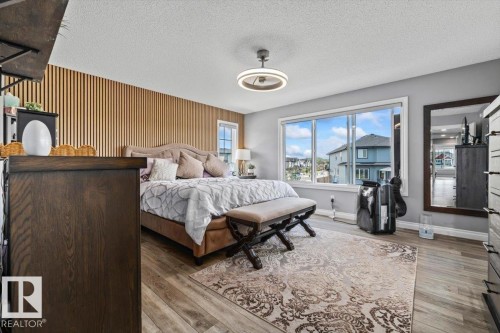 Bedroom featuring wood-finish flooring and a distinctive slat wall accent - 5203 23A Avenue Sw, Edmonton, AB - Indoor Photo Showing Bedroom