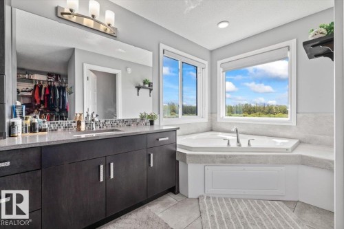 Corner soaking tub with surrounding windows and tile surround - 5203 23A Avenue Sw, Edmonton, AB - Indoor Photo Showing Bathroom