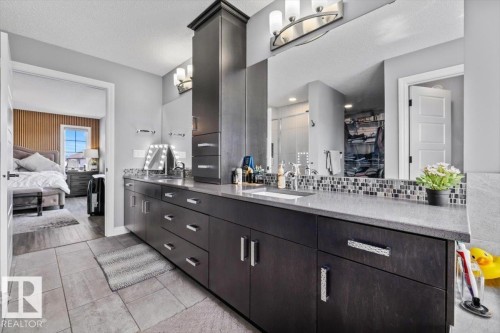 Dual vanity with dark wood-finish cabinetry, integrated sinks, and polished chrome hardware - 5203 23A Avenue Sw, Edmonton, AB - Indoor