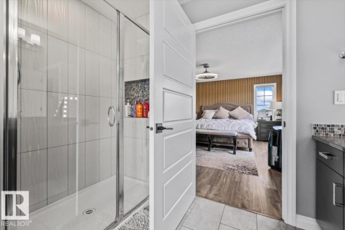 Glass-enclosed shower with white tiled walls and built-in storage niche featuring mosaic tile - 5203 23A Avenue Sw, Edmonton, AB - Indoor Photo Showing Bathroom