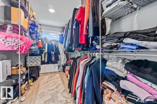 Walk-in closet featuring extensive wire shelving, hanging rods, recessed lighting, and wood-finish flooring - 5203 23A Avenue Sw, Edmonton, AB - Indoor With Storage