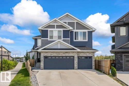 Two-story residence featuring a combination of blue siding, gray shingles, and stone veneer accents - 5203 23A Avenue Sw, Edmonton, AB - Outdoor With Facade