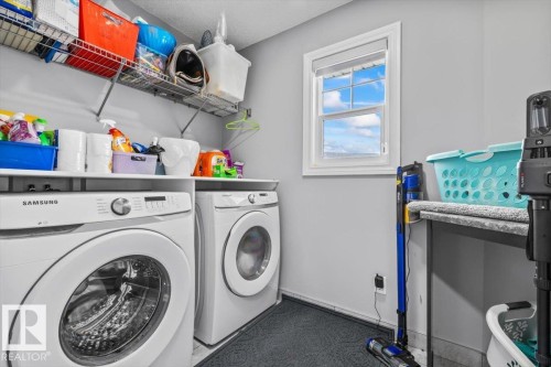 Dedicated laundry area featuring a window, built-in shelving, and a countertop space - 5203 23A Avenue Sw, Edmonton, AB - Indoor Photo Showing Laundry Room