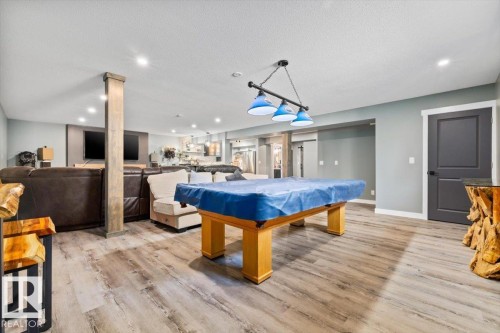 Recreational space featuring wood-finish flooring, recessed lighting, and a distinct ceiling light fixture - 5203 23A Avenue Sw, Edmonton, AB - Indoor Photo Showing Other Room