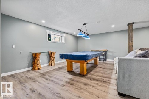 Recreation room featuring wood-finish flooring, recessed lighting, and a window for natural light - 5203 23A Avenue Sw, Edmonton, AB - Indoor Photo Showing Other Room