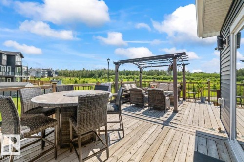 Expansive wood deck featuring a pergola, wood railing, and exterior wall lighting fixtures - 5203 23A Avenue Sw, Edmonton, AB - Outdoor With Deck Patio Veranda With Exterior