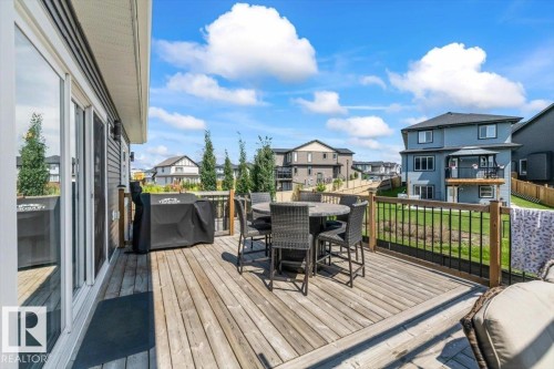 Spacious wood deck featuring black metal railings and a glass patio door - 5203 23A Avenue Sw, Edmonton, AB - Outdoor With Deck Patio Veranda With Exterior
