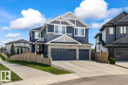 Contemporary two-story exterior featuring blue siding, light gray shingle accents, and stone facade - 5203 23A Avenue Sw, Edmonton, AB - Outdoor With Facade