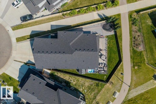 Expansive backyard featuring a wood-finish deck with railings, a built-in hot tub, and a manicured lawn - 5203 23A Avenue Sw, Edmonton, AB -  With View
