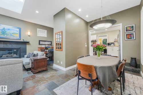 Vaulted ceilings, skylight, recessed lighting, stone tile flooring, and a fireplace with a dark mantel - 10531 137 Street Nw, Edmonton, AB 