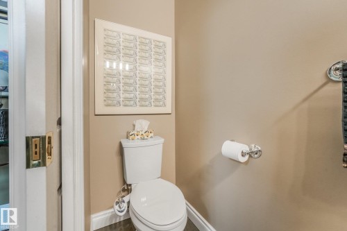 White toilet with chrome hardware - 10531 137 Street Nw, Edmonton, AB 