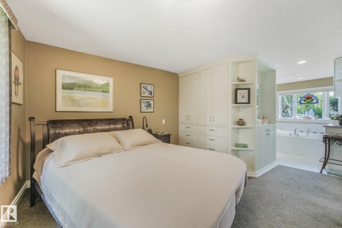Built-in cabinetry with integrated shelving, recessed lighting, and a bay  window above a large soaking tub - 10531 137 Street Nw, Edmonton, AB 
