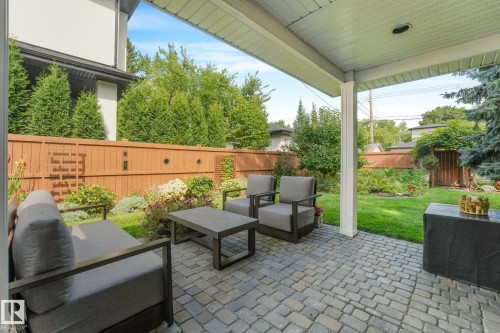 Covered patio featuring a paver stone surface, white columns, and a wood privacy fence - 10531 137 Street Nw, Edmonton, AB 