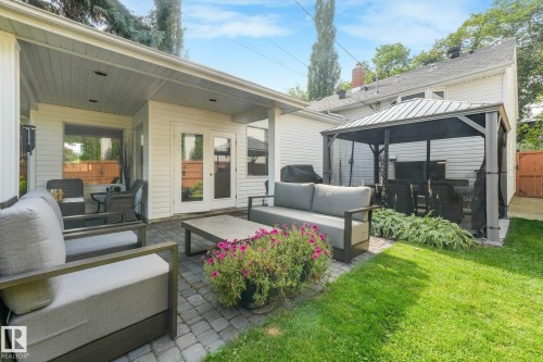 Paved patio area, covered outdoor living space, French doors, manicured lawn, and a gazebo structure - 10531 137 Street Nw, Edmonton, AB 
