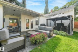 Paved patio area, covered outdoor living space, French doors, manicured lawn, and a gazebo structure - 