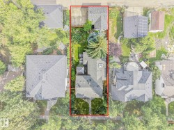 Expansive lot featuring mature trees, a detached garage, and a manicured lawn - 