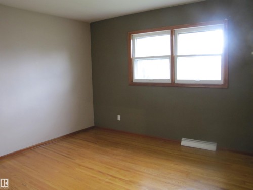 Hardwood flooring, wood-framed window, and two-tone wall finishes - 9512 63 Avenue Nw, Edmonton, AB 