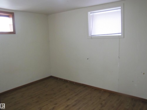 Wood-finish flooring with light-toned walls and trim, featuring two windows - 9512 63 Avenue Nw, Edmonton, AB 