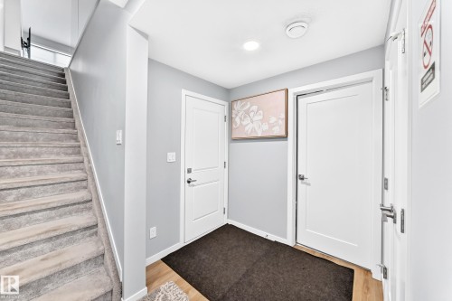 Carpeted staircase, wood-finish flooring, recessed lighting, and white interior doors - 479 39 St Sw, Edmonton, AB 