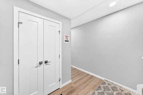 White double doors with satin nickel hardware, recessed ceiling lighting, and wood-finish flooring - 479 39 St Sw, Edmonton, AB 