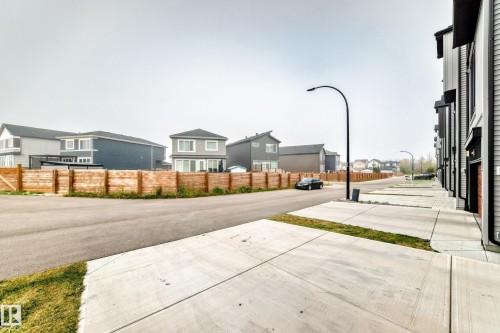 Modern residential streetscape with concrete sidewalks and a streetlamp - 479 39 St Sw, Edmonton, AB 