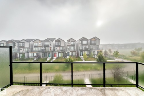 Concrete balcony with a black metal and frosted glass railing - 479 39 St Sw, Edmonton, AB 