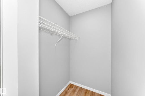 Wire shelving system with a hanging rod and wood-finish flooring - 479 39 St Sw, Edmonton, AB 