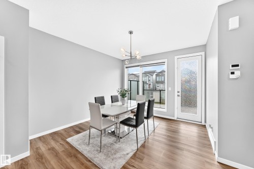 Wood-finish flooring, light grey walls, and a contemporary chandelier - 479 39 St Sw, Edmonton, AB 