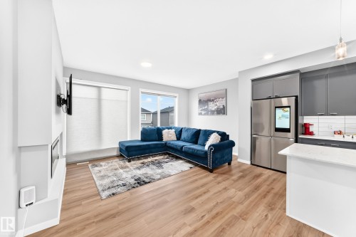 Open-concept living space featuring wood-finish flooring, recessed lighting, and a built-in fireplace - 479 39 St Sw, Edmonton, AB 
