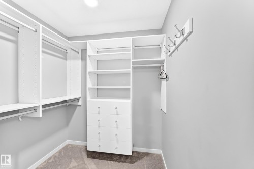 Custom closet organization system with integrated drawers, shelving, and hanging rods - 479 39 St Sw, Edmonton, AB 