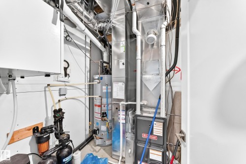 Utility area featuring a water heater, furnace, and water filtration system - 479 39 St Sw, Edmonton, AB 