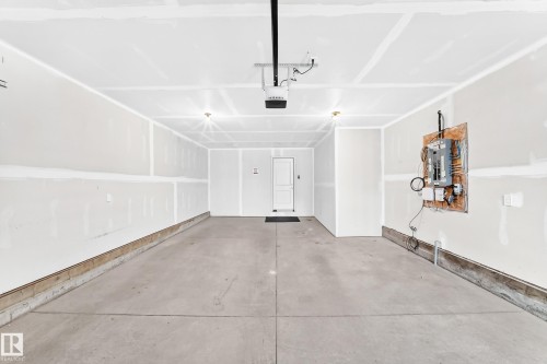 Concrete flooring, overhead lighting, garage door opener, interior access door, exposed electrical panel - 479 39 St Sw, Edmonton, AB 