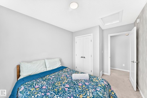 Recessed lighting, wood-finish bed frame, light gray wall paint, white trim, and a white interior door - 479 39 St Sw, Edmonton, AB 