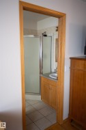 Tile flooring extending into the shower area, full vanity with integrated sink, and an enclosed shower - 