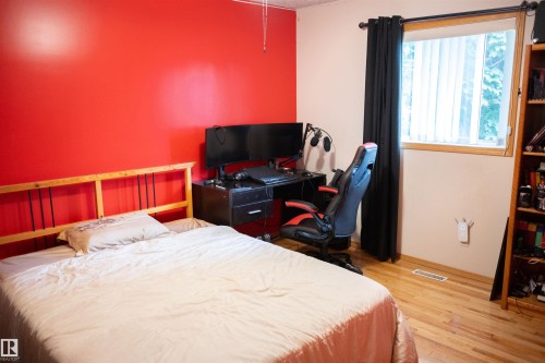 Hardwood-style flooring, light wood window trim, and a built-in shelving unit - 16503 68 Street Nw, Edmonton, AB 