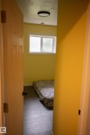 Room featuring light yellow walls, a window with white trim, and wood-finish flooring - 