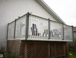 Raised outdoor deck featuring white painted railings and a lattice skirt - 