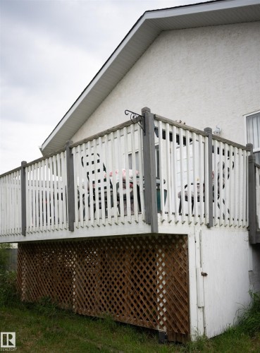 Elevated outdoor deck with white picket railing, featuring a wood lattice skirting - 16503 68 Street Nw, Edmonton, AB 