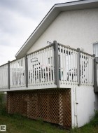 Elevated outdoor deck with white picket railing, featuring a wood lattice skirting - 