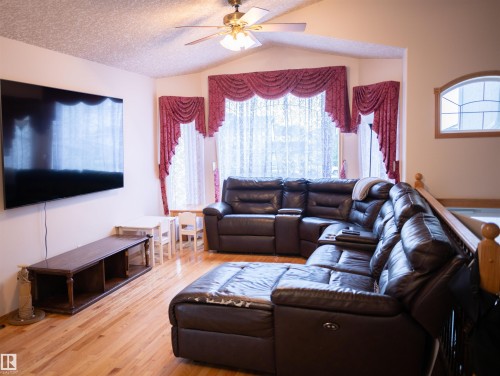 Vaulted ceiling with ceiling fan, wood-finish flooring, bay windows, and arched transom window - 16503 68 Street Nw, Edmonton, AB 