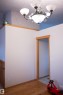 Wood-finish flooring with coordinating wood trim, a built-in chandelier with frosted glass shades, and a wood-trimmed doorway - 16503 68 Street Nw, Edmonton, AB 