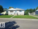 White siding exterior with a pitched roof, concrete front walkway, and a concrete driveway - 9504 63 Avenue Nw, Edmonton, AB 
