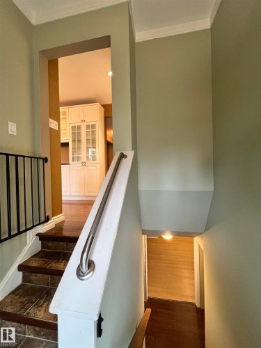 Staircase featuring tile treads, wood-finish risers, and a metal handrail - 15003 81 Street Nw, Edmonton, AB 