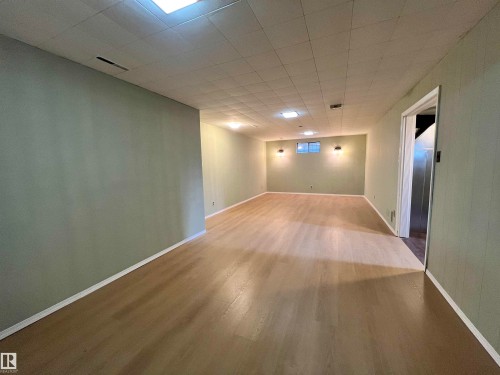 Expansive room featuring light wood-finish flooring, recessed lighting, and wall-mounted sconces - 15003 81 Street Nw, Edmonton, AB 